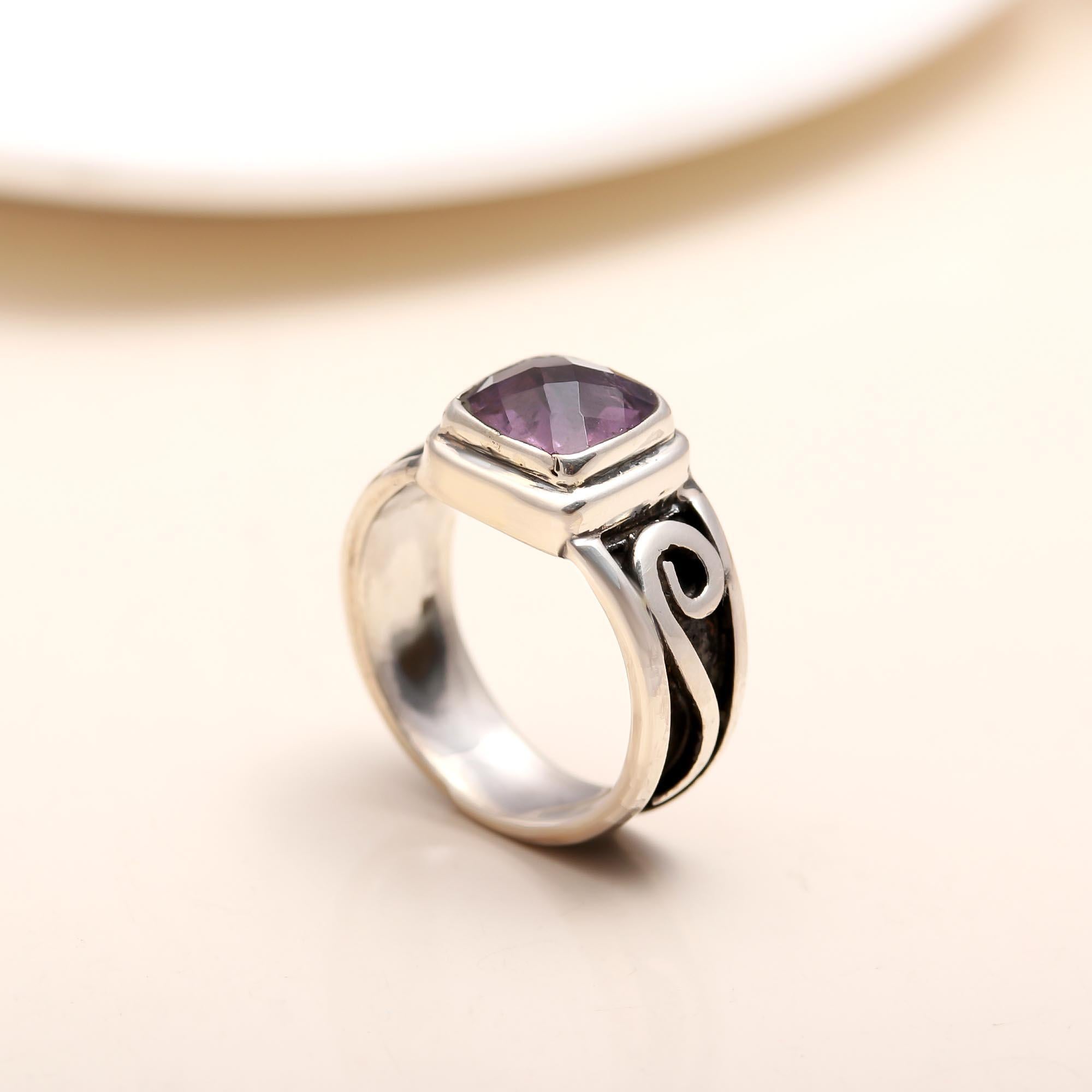 Artistic silver ring featuring amethyst gemstone and flowing band design