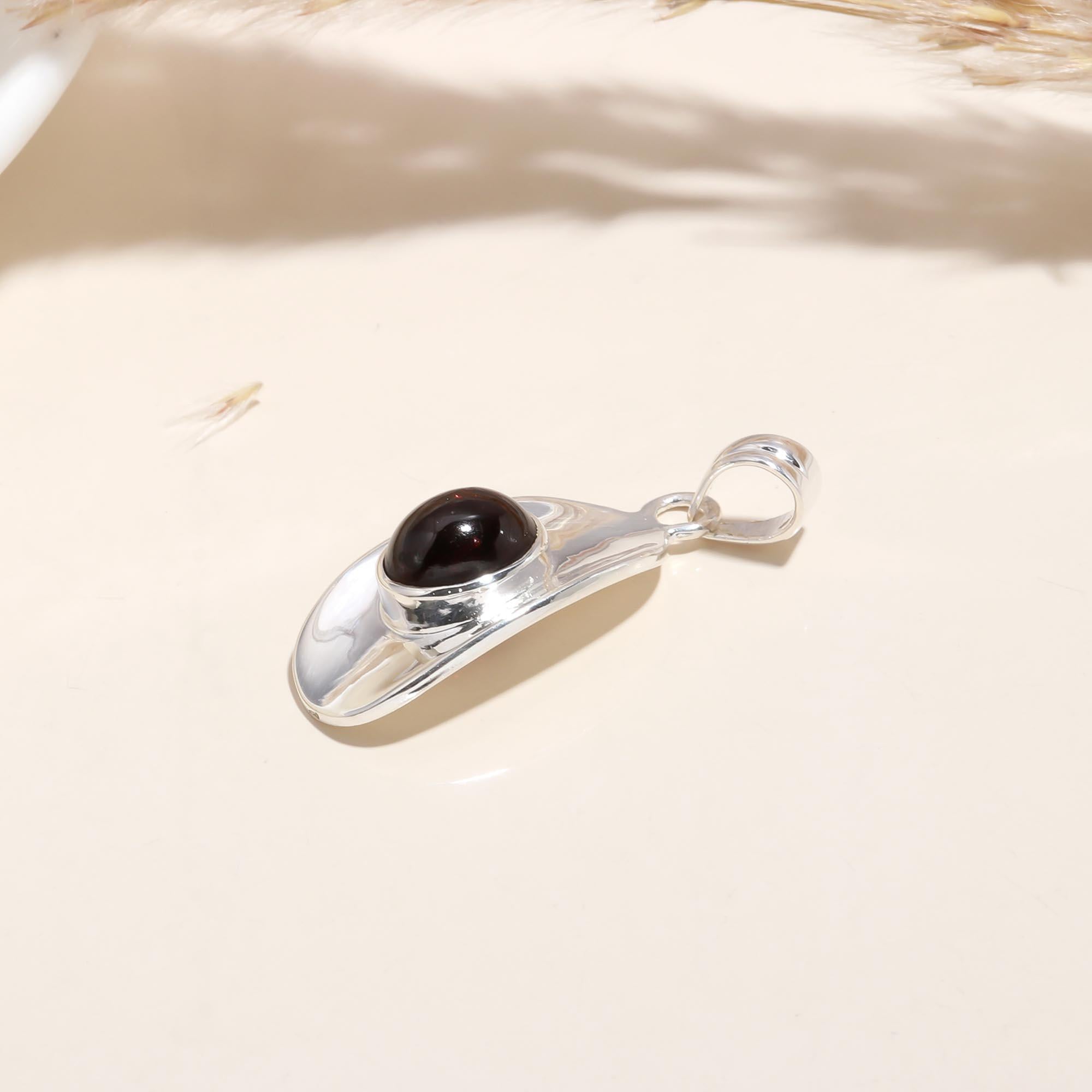 The Sculptural Shield: Modern Garnet Polished Silver Pendant