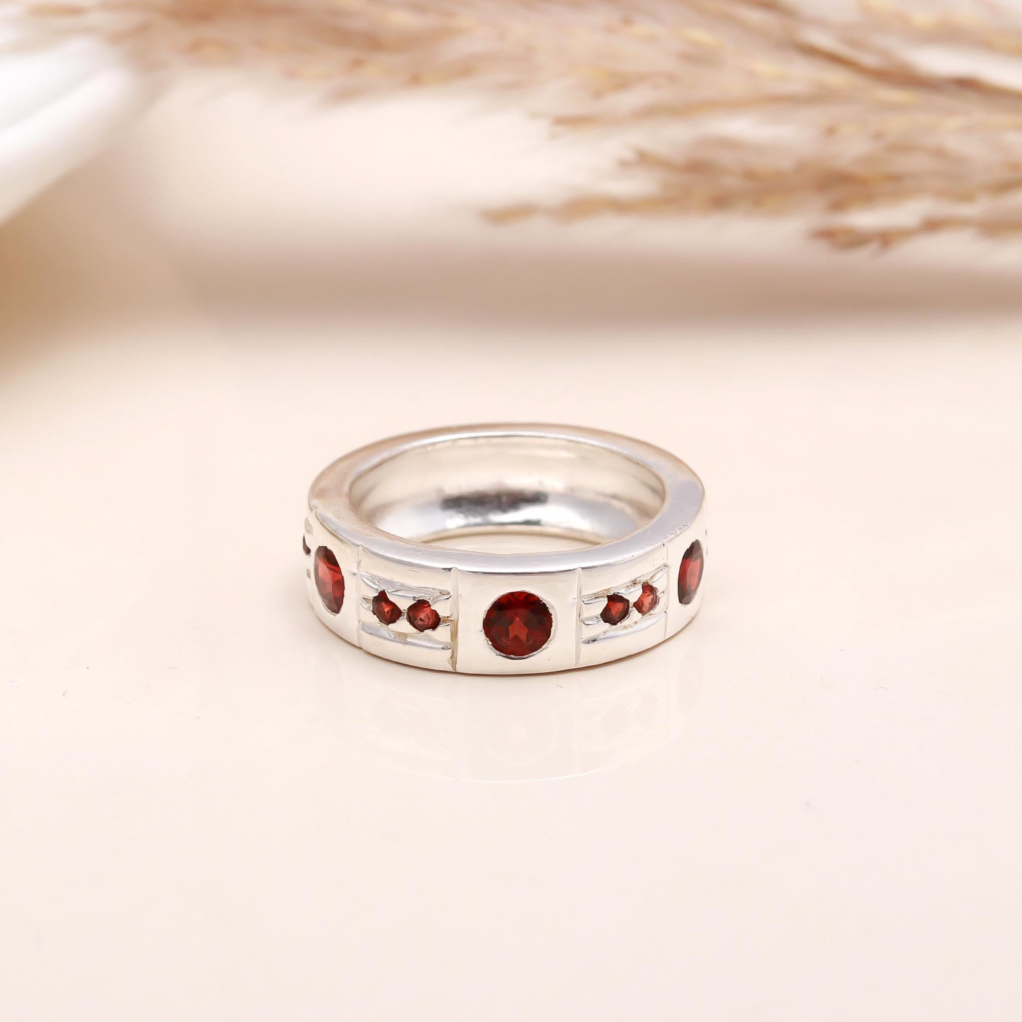 Close-up of red garnet studded silver ring