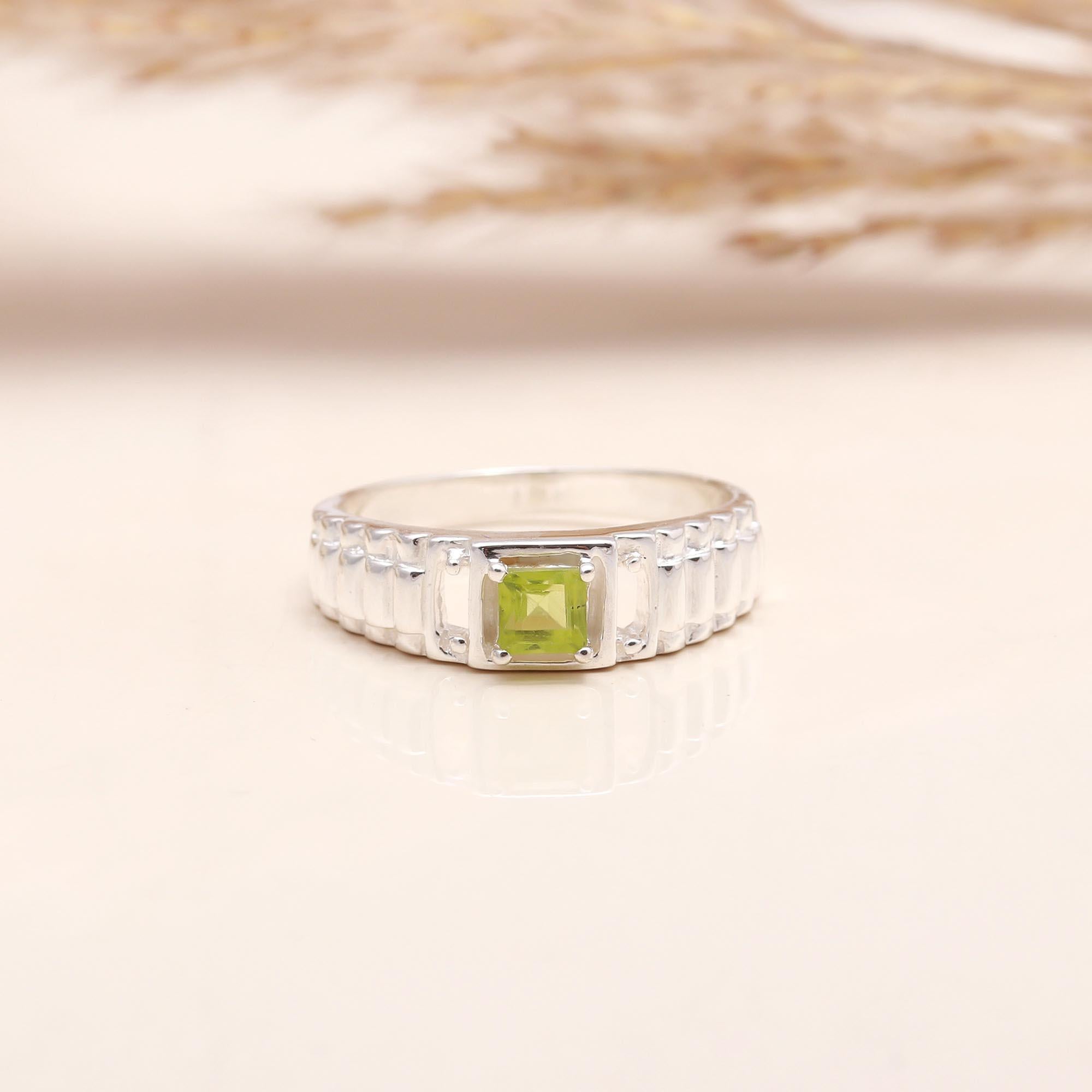 Close-up of square peridot textured silver band ring