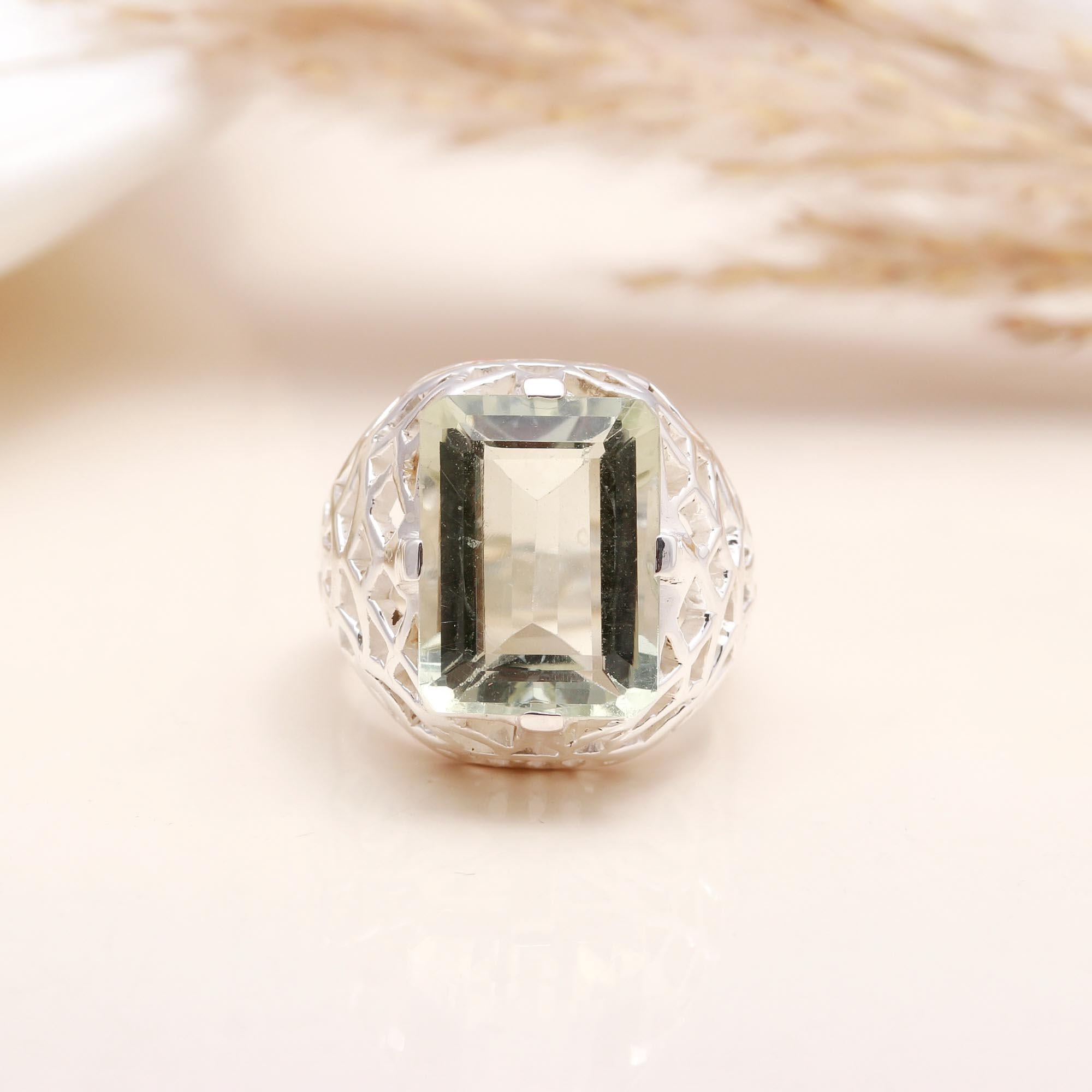 Close-up of emerald cut green amethyst silver filigree ring