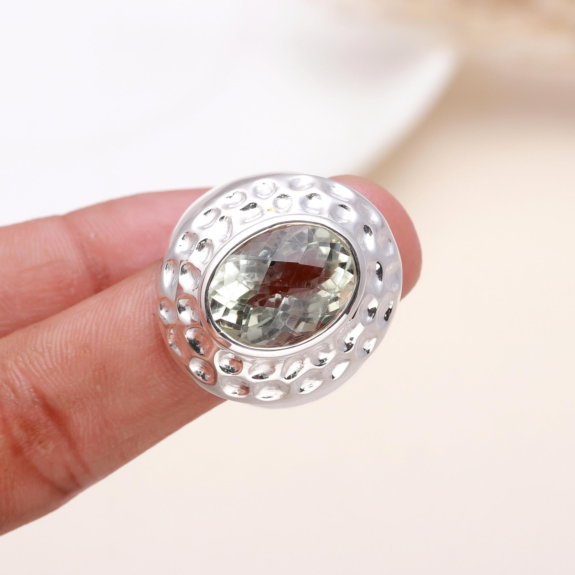Oval green amethyst ring on finger with textured band