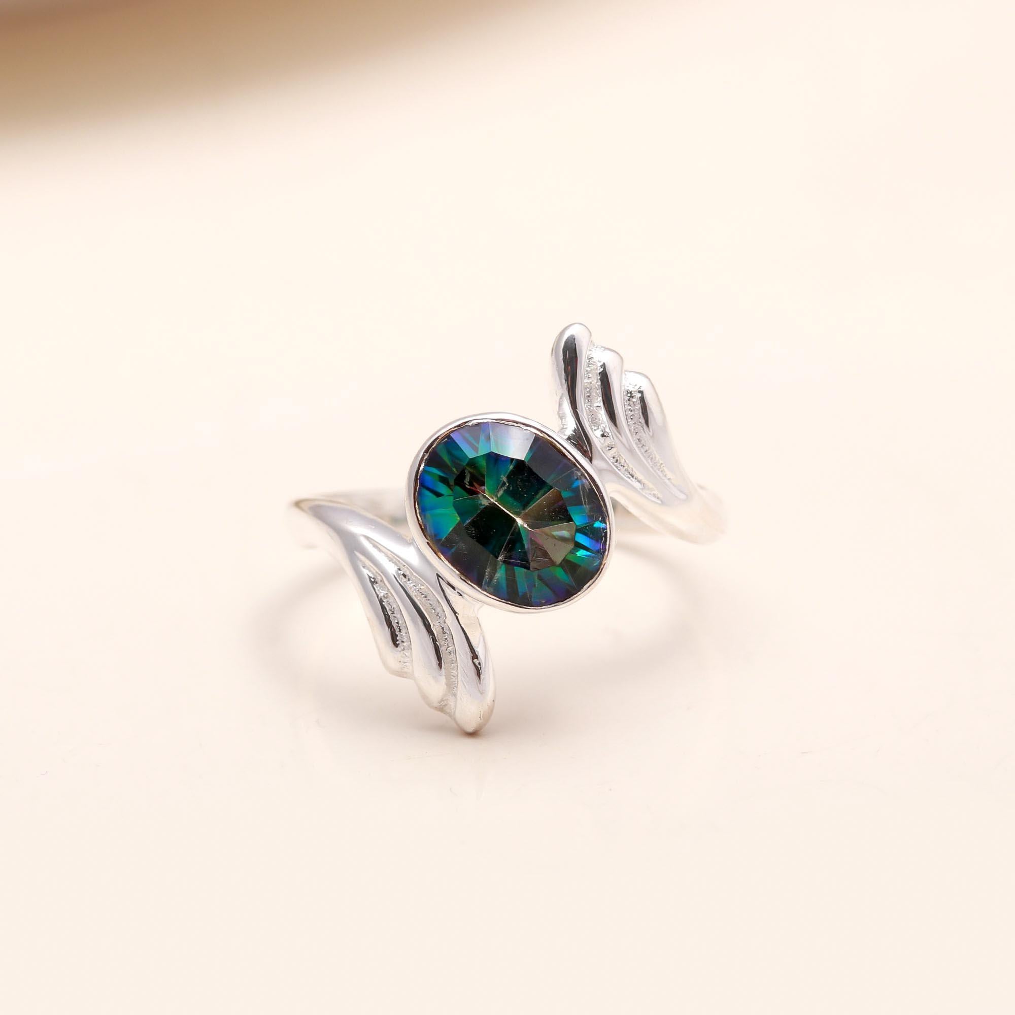 Close-up of oval mystic topaz open wing silver ring